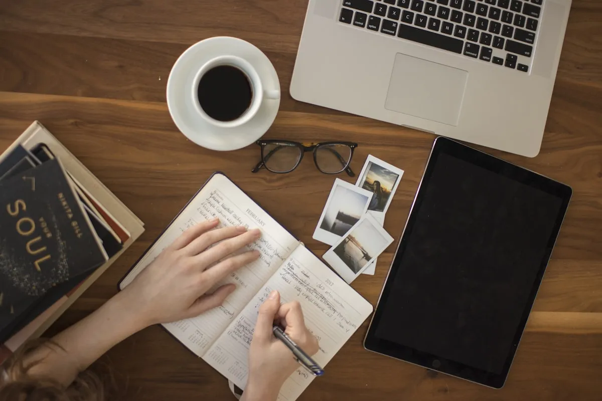 Person writing thoughtfully at desk with coffee -working through brain fog