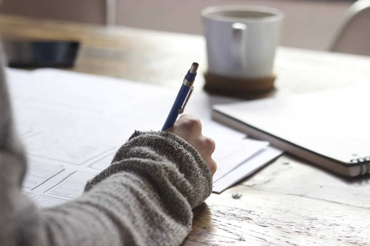Person holding pen over blank paper -executive dysfunction and writing