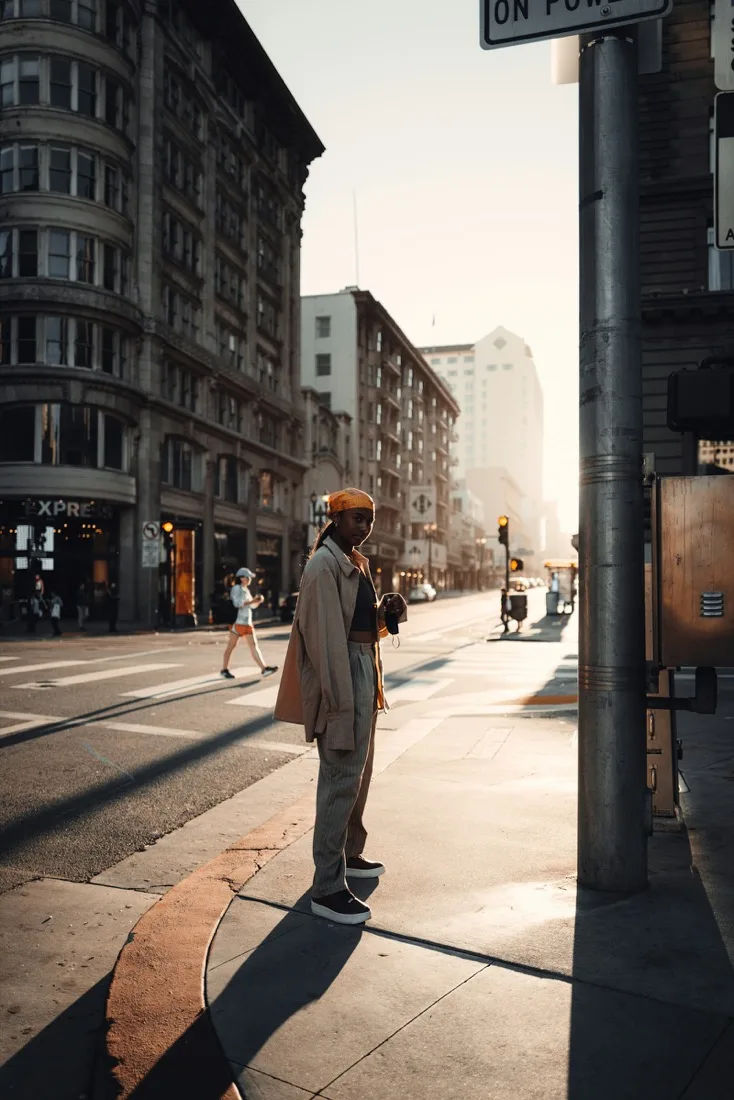 Man standing at the side of a road outdoors talking into his phone